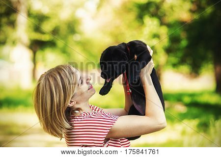 young beautiful woman with a white puppy labrador retrievers. dogs and woman. outdoor portrait. Beautiful woman playing with her dog.