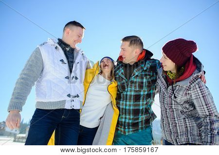 Cheerful group of friends posing for the camera. Two young men and two girl. All good mood. Friends are hugging and laughing merrily.