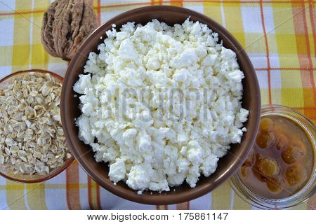 Cottage cheese in a brown bowl with oatmeal and jam