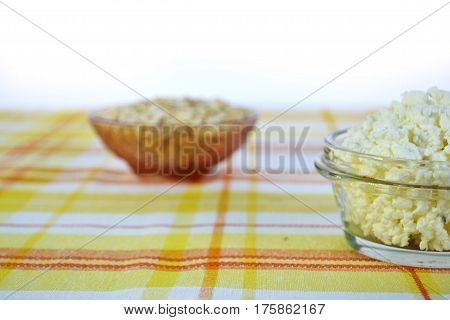 Cottage cheese in a brown bowl with oatmeal and jam