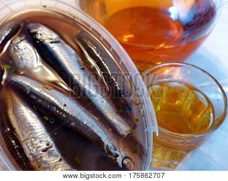 A glass of vodka and bank with spicy salting anchovys. Vodka honey with pepper (Home tincture fortress 45 degrees). Decanter with vodka (tincture). Closeup. Natural food. Traditional Russian cuisine.