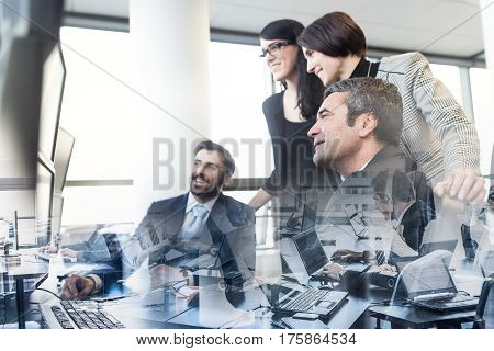 Business team looking at data on multiple computer screens in corporate office. Business people trading online. Business, entrepreneurship and team work concept.