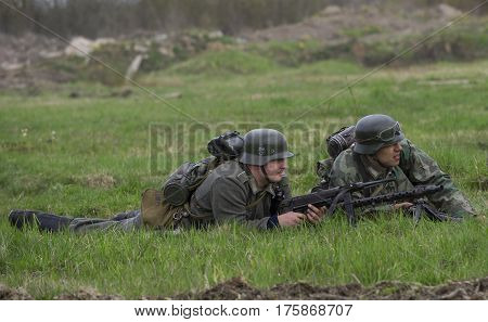 LENINGRAD REGION, RUSSIA - MAY 05, 2015: Two Wehrmacht soldiers lying on the grass. Reconstruction of the episode of the great Patriotic war