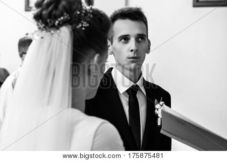 Happy Stylish Bride And Elegant Groom Exchanging Vows At Catholic Wedding Ceremony At Church