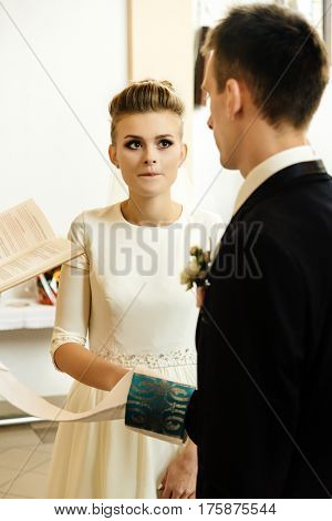 Happy Stylish Bride And Elegant Groom Exchanging Vows At Catholic Wedding Ceremony At Church