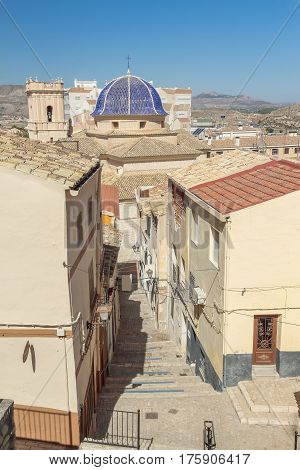 nice steep street with stairs and the church of san bartolome in the background in the town of Petrer in the province of alicante spain