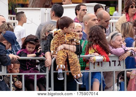 Viewers From Behind Dividing Fence Look At The сarnival Parade