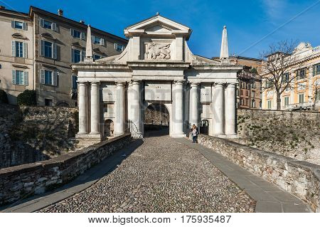 BERGAMO, ITALY - DECEMBER 2016: People near city gates of San Marco in Bergamo town, Italy.