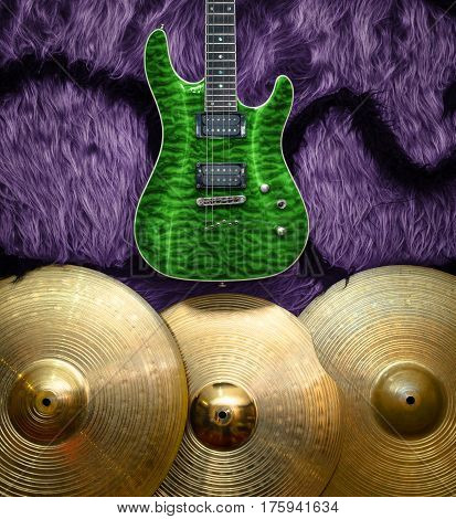 Green electric guitar with three cymbals on faux fur wall. Musical instruments background