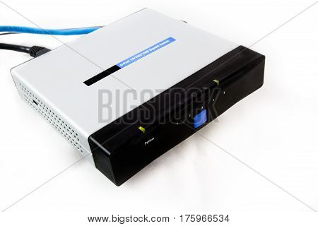LAN network switch with plugged blue ethernet cable isollated on a white background