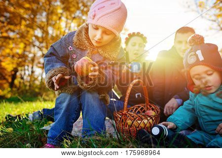 Girl Sitting On The Grass With An Apple In His Hand
