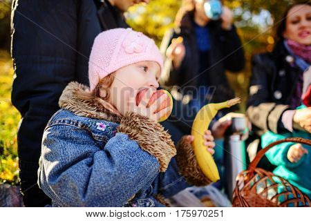 Girl Sitting On The Grass With An Apple In His Hand