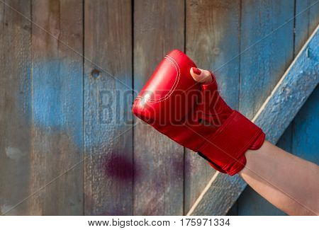 Red leather boxing glove on a woman's hand empty space on the left