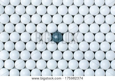 Black Bulb Among Many White Ones. Background Of Airsoft Balls
