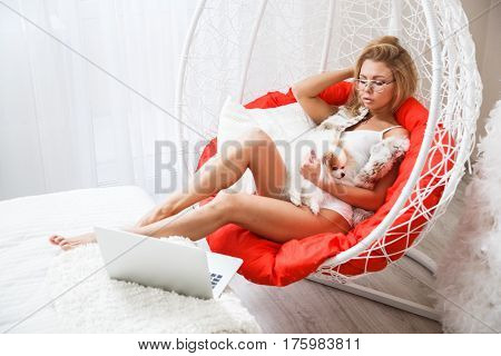 Beautiful girl sexy blonde in lingerie posing in the bathroom with the dog