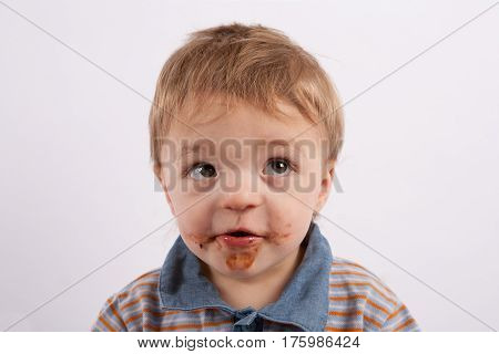 Portrait of a funny baby boy with mouth covered with chocolate