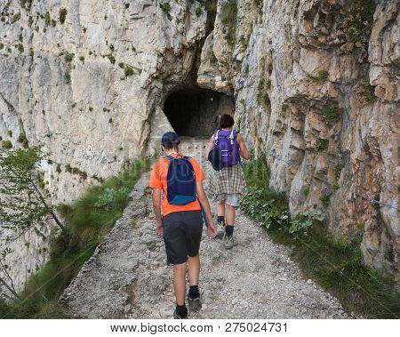 Mother And Son Walk On The Steep Mountain Path Of The 52 Tunnels On Mount Pasubio In Veneto