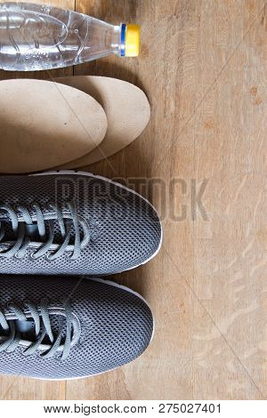 Gray Sport Shoes  With Nordic Walking Sticks, Orthopedic Insoles And Bottle Of Waterr.  Pair Of Snea