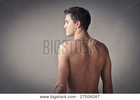잘 지어진된 bare-chested 젊은 남자의 뒷 모습