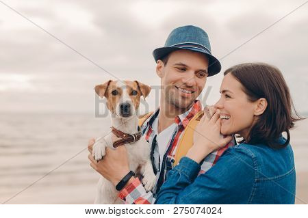 People, Vacation Concept. Horizontal Shot Of Pleased Young Woman And Man Dressed In Hat And Shirt, C