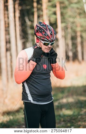 Training An Athlete On The Roller Skaters. Biathlon Ride On The Roller Skis With Ski Poles, In The H