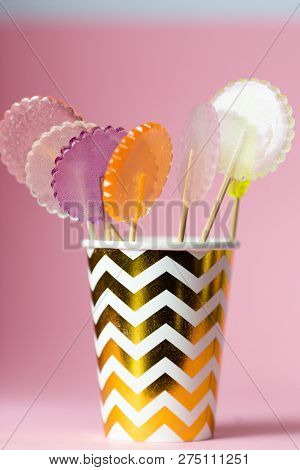 Multi-colored Lollipops On A Pink Background With Decoration, In With Paper Cup, Close Up