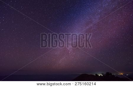 Night Landscape With Colorful Milky Way And Yellow Light At Mountains At Doi Mon Jong, Chiang Mai, T
