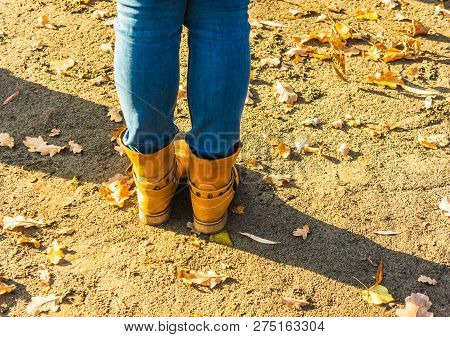 Women Legs In Jeans And Boots In The Autumn.