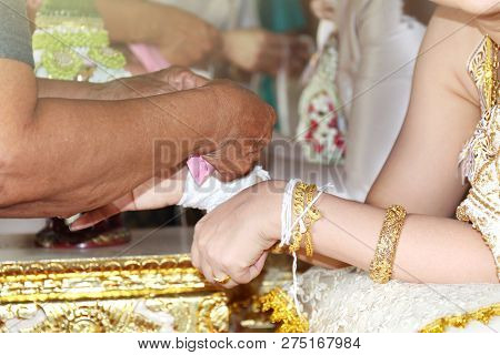Traditional Thai Wedding, The Bride's Hands Are Tied With Thread From The Older Culture Of Tradition