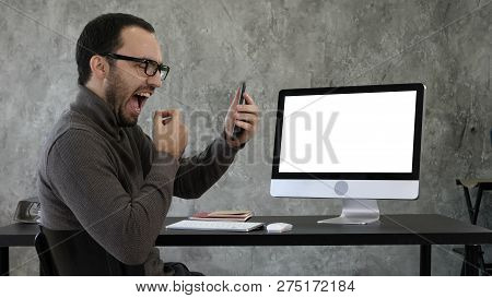 Man Checking His Teeth In The Office Near Computer Screen. White Display.