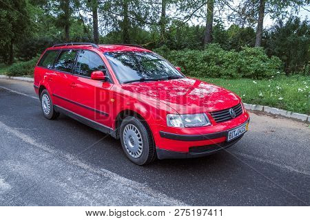 City Cesis, Latvia. Red Wolksvagen Passat B5 To Street, Trees An Way. Travel Photo 2012.
