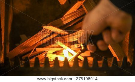 Starting Fire In Stove, Male Hand With Lighter Igniting A Pile Of Firewood, Traditional Heating Heat