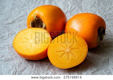 Whole And Half Of Fresh Ripe Persimmons. Japanese Persimmon (diospyros Kaki)
