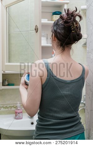The Girl Opens The Mirror Cabinet Above The Sink And Picks Up The Cosmetics . The View From The Back
