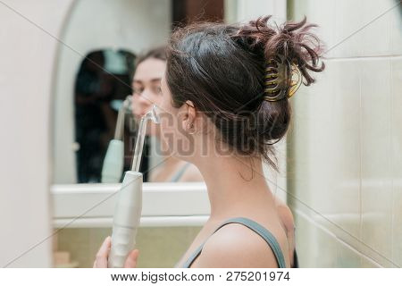 The Girl Opens The Mirror Cabinet Above The Sink And Picks Up The Cosmetics . The View From The Back