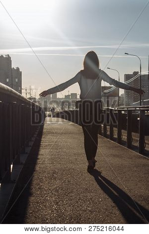 Girl Walking On The Road Towards Sunset