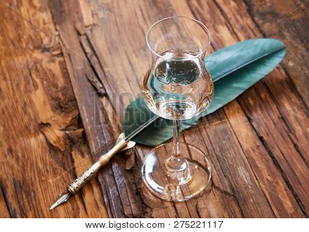 Grappa In A Small Glas On Old Wooden Table