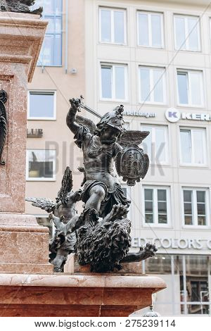 Germany, Munich - September 01, 2013. Statue Of Putto Killing A Dragon On The Marian Columns Pedesta
