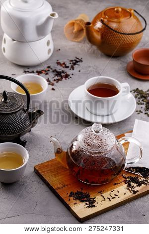 Tea Card. Variety Of Teapots On A Gray Background, Different Types Of Tea. Range. Tea Still Life.