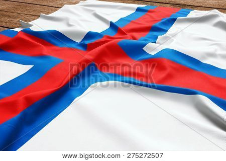 Flag Of Faroe Islands On A Wooden Desk Background. Silk Faroese Flag Top View.