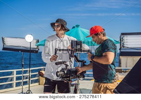 Steadicam Operator And His Assistant Prepare Camera And 3-axis Stabilizer-gimbal For A Commercial Sh