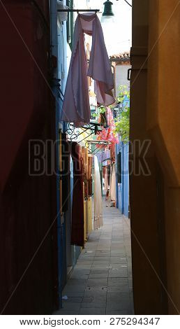 Narrow Street Called Calle In Italian Language In The Island Of Burano Near Venice In Italy