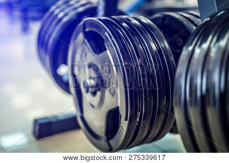 Fitness Exercise Equipment Barbells In The Sports Gym. Black Barbell Plates In Sport Fittness Center