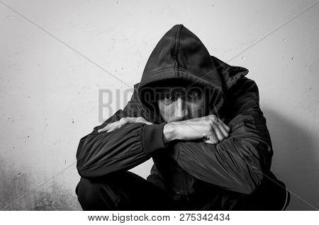 Homeless Man Drug And Alcohol Addict Sitting Alone And Depressed On The Street In Winter Clothes Fee