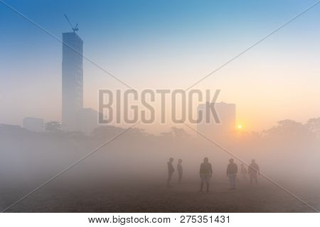 Beautiful Image Of Sunrise At Kolkata Maidan In A Foggy Winter Morning. Sunrises At The Horizon Abov