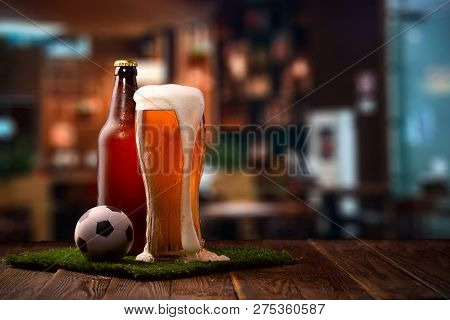 Photo Of Buttle And Glass Of Beer, Soccer Ball On Green Grass On The Bar Counter.