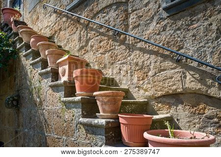 Flower Pots At The Steps Of Civita Di Bagnoregio Old House. Tuscany, Italy.