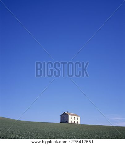 Little Summer House In Grass Field With Clear Blue Sky