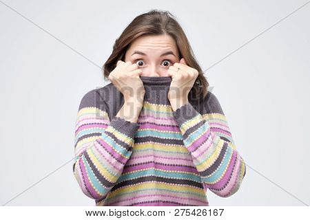Girl Pulling Her Trendy Sweater Over Head Having Fun Being Childish Disappearing In Her Clothes