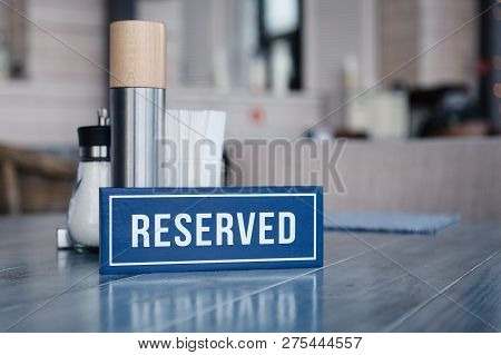 Closeup Wooden Blue White Rectangular Plate With The Word Reserved Standing On Gray Vintage Table In